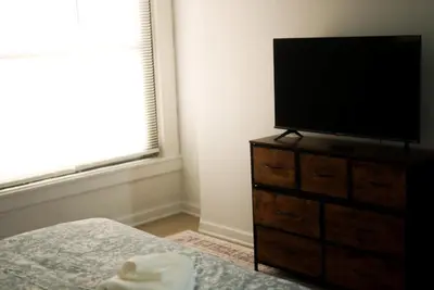 a bedroom with a flat screen tv on a dresser at Charming 2 Bedroom Loft in Cleveland