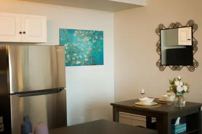 a kitchen with a refrigerator and a table with a mirror at Charming 2 Bedroom Loft in Cleveland