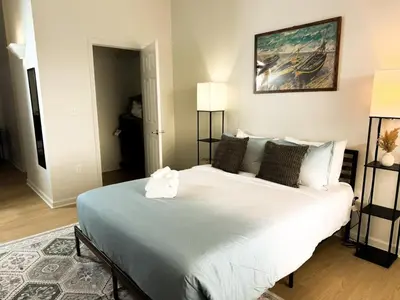 a bedroom with a large white bed with a painting on the wall at Charming 2 Bedroom Loft in Cleveland