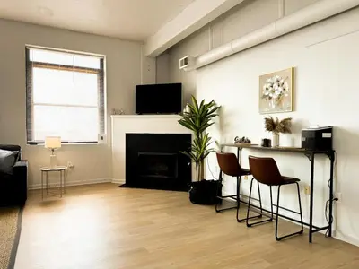 a living room with a fireplace and a table and chairs at Charming 2 Bedroom Loft in Cleveland