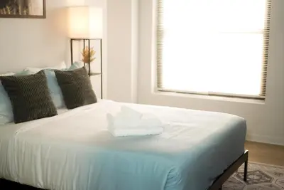 a white bed with two folded towels on it at Charming 2 Bedroom Loft in Cleveland