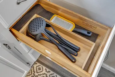 a wooden drawer with some utensils in it at South Euclid 3BR Cozy Winter Escape in South Euclid