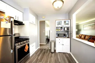a small kitchen with a stove and a living room at Maple Heights 3BR Cozy and Spacious in Maple Heights
