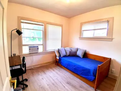 a bedroom with a blue bed and two windows at Cozy 2BR Lyndhurst Retreat in Lyndhurst