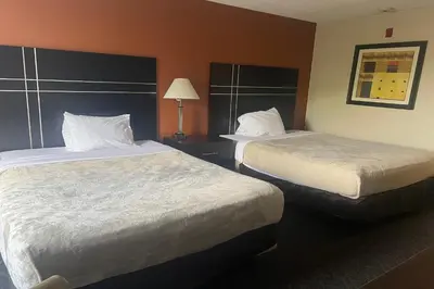 a hotel room with two beds and a lamp at Hotel Inn Columbus in Columbus