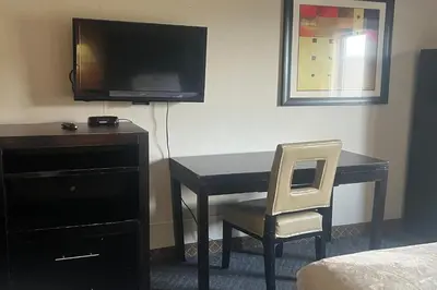 a room with a desk with a television and a chair at Hotel Inn Columbus in Columbus
