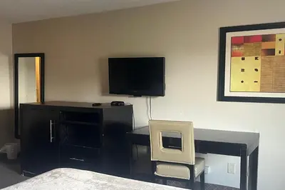 a bedroom with a desk and a tv and a chair at Hotel Inn Columbus in Columbus