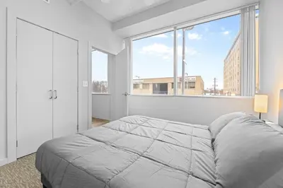 a bedroom with a bed and a large window at Spacious 2 BD Apt l Downtown Cleveland l Free Parking in Cleveland
