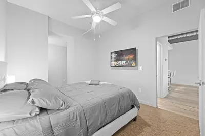 a white bedroom with a bed with a ceiling fan at Spacious 2 BD Apt l Downtown Cleveland l Free Parking in Cleveland