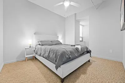 a white bedroom with a bed and a ceiling fan at Spacious 2 BD Apt l Downtown Cleveland l Free Parking in Cleveland