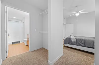 a white bedroom with a bed and a mirror at Spacious 2 BD Apt l Downtown Cleveland l Free Parking in Cleveland