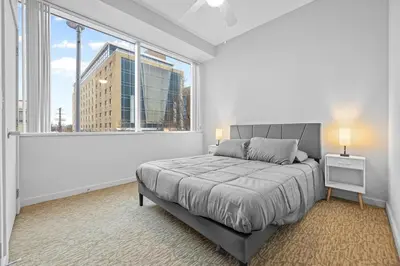 a bedroom with a bed and a large window at Spacious 2 BD Apt l Downtown Cleveland l Free Parking in Cleveland