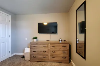 a bedroom with a dresser with a television on the wall at Cozy 2BR, Near Top attractions in Covington
