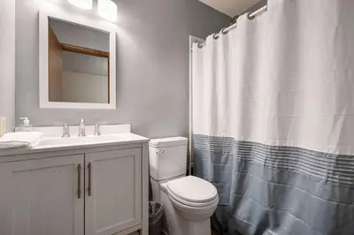 a bathroom with a toilet and a sink and a mirror at The Family Nook - Home for 8 in Hamilton