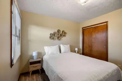 a bedroom with a large bed and a wooden door at The Family Nook - Home for 8 in Hamilton