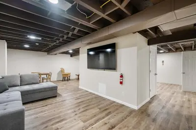 a living room with a couch and a flat screen tv at The Family Nook - Home for 8 in Hamilton