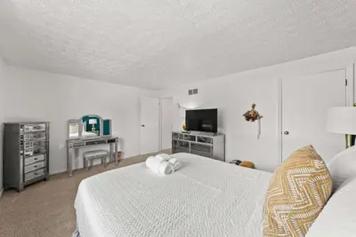 a bedroom with a white bed and a television at The StayBerry - Stay for 6 in Columbus