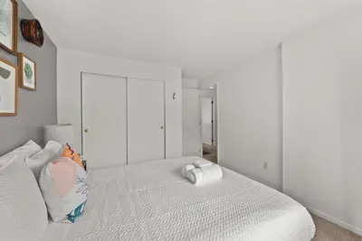 a white bedroom with a bed with two pillows at The StayBerry - Stay for 6 in Columbus