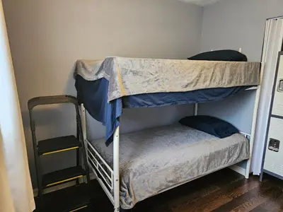two bunk beds in a room with a ladder at Navarre Guest Rooms in Columbus