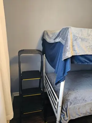 a bunk bed with a ladder next to a bunk bed with at Navarre Guest Rooms in Columbus