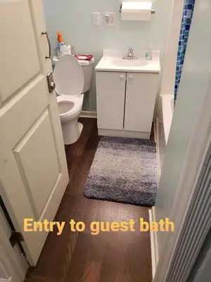 an entry to a bathroom with a toilet and a sink at Navarre Guest Rooms in Columbus