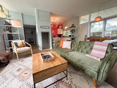 a living room with a green couch and a coffee table at Mid-Century Modern Themed Home with Outdoor Hot Tub in Vermilion