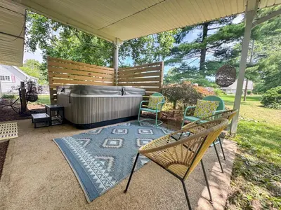 a patio with a hot tub and chairs on a rug at Mid-Century Modern Themed Home with Outdoor Hot Tub in Vermilion