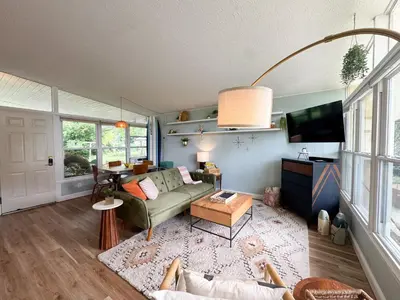 a living room with a couch and a tv at Mid-Century Modern Themed Home with Outdoor Hot Tub in Vermilion