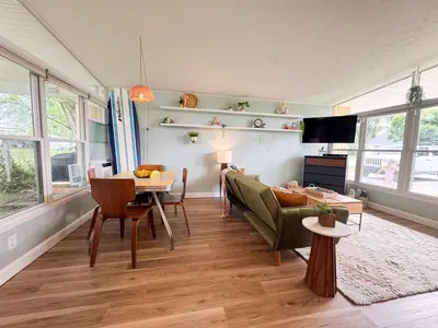 a living room with a couch and a table at Mid-Century Modern Themed Home with Outdoor Hot Tub in Vermilion