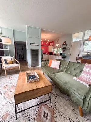 a living room with a green couch and a coffee table at Mid-Century Modern Themed Home with Outdoor Hot Tub in Vermilion