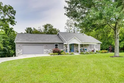 a house with a garage and a grass yard at 4 Mi to Dtwn Ohio River Valley Home with Deck! in Aurora
