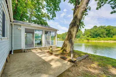 a house with a tree on the side of it at Cozy House on Meadowbrook Lake Serene, Scenic! in Stow