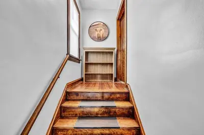 a hallway with a staircase with a clock on the wall at Suite Dreams Cleveland in Shaker Heights