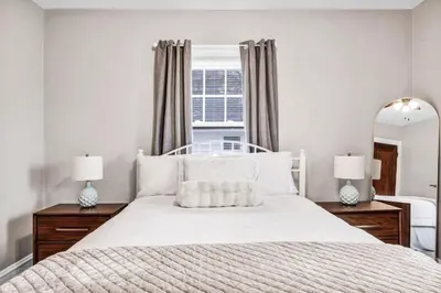 a bedroom with a large bed and a mirror at Suite Dreams Cleveland in Shaker Heights