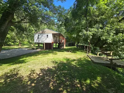 a cabin in the middle of a field with trees at River's Rest on Hocking River in Coolville
