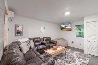 a living room with a leather couch and a table at Riverstone Cabin and Retreat in West Liberty