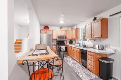 a kitchen with wooden cabinets and a counter top at Riverstone Cabin and Retreat in West Liberty