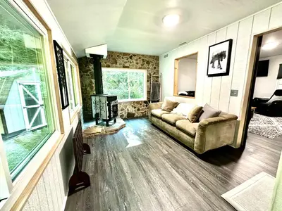 a living room with a couch and a fireplace at Riverstone Cabin and Retreat in West Liberty