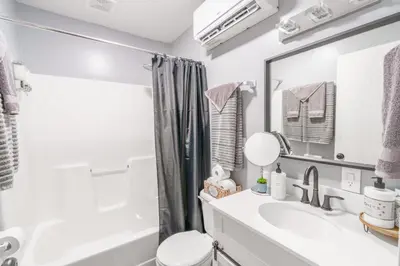 a white bathroom with a sink and a mirror at Riverstone Cabin and Retreat in West Liberty