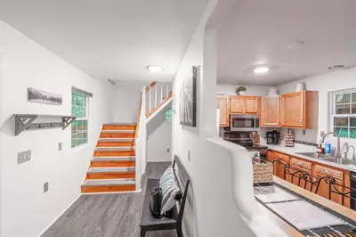 a kitchen with white walls and wooden cabinets at Riverstone Cabin and Retreat in West Liberty