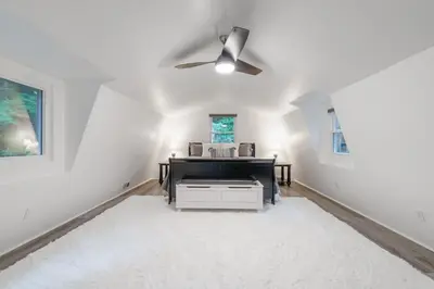 a living room with a ceiling fan and a piano at Riverstone Cabin and Retreat in West Liberty