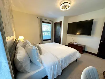 a bedroom with a white bed and a flat screen tv at The Dayton DreamHouse in Dayton