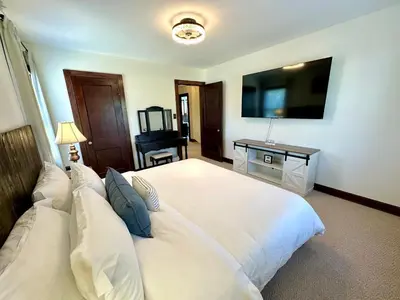 a bedroom with a large white bed and a desk at The Dayton DreamHouse in Dayton