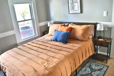 a bedroom with a large bed with pillows and a window at Lakewood Entire Home! Sleeps 10! in Lakewood
