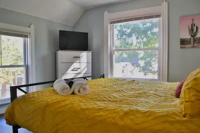 a bedroom with a yellow bed with towels on it at Lakewood Entire Home! Sleeps 10! in Lakewood