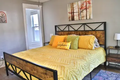 a bedroom with a bed with yellow and green pillows at Lakewood Entire Home! Sleeps 10! in Lakewood