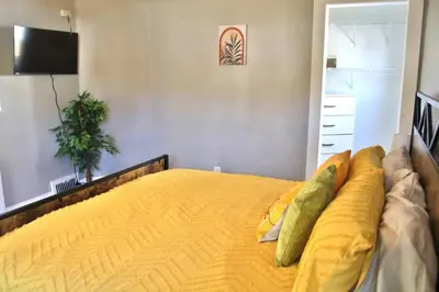 a bedroom with a large bed with yellow sheets at Lakewood Entire Home! Sleeps 10! in Lakewood