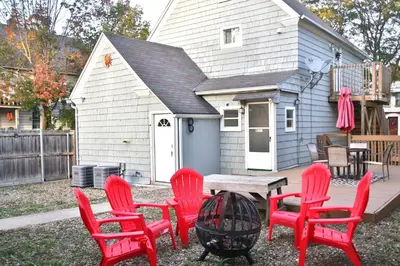 a group of red chairs and a table in front of a house at Lakewood Entire Home! Sleeps 10! in Lakewood