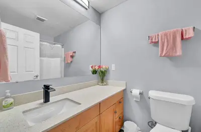 a bathroom with a sink and a toilet and a mirror at Pink playhouse sq near Progressive field & CSU in Cleveland