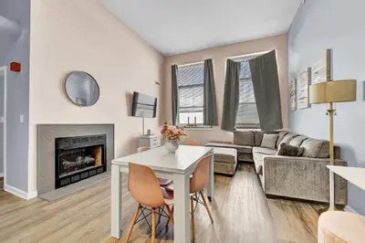 a living room with a table and a fireplace at Pink playhouse sq near Progressive field & CSU in Cleveland
